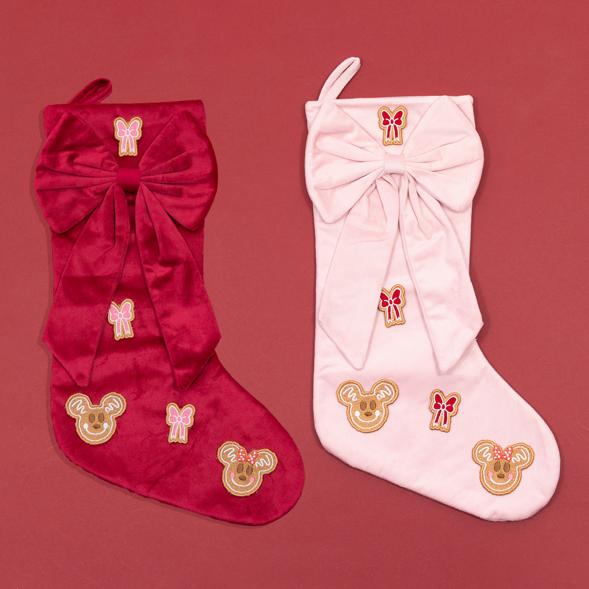 Red and pink Christmas stockings with oversized bows, Mickey and Minnie gingerbread embroidery and contrasting embroidered bows.