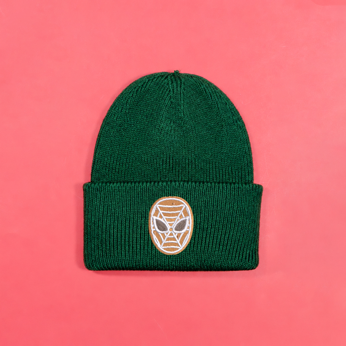 Bottle green knitted beanie with gingerbread-style Spider-Man mask embroidery on the turned-up cuff.