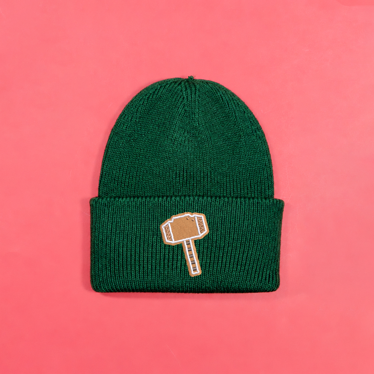 Bottle green knitted beanie with gingerbread-style Thor hammer embroidery on the turned-up cuff.