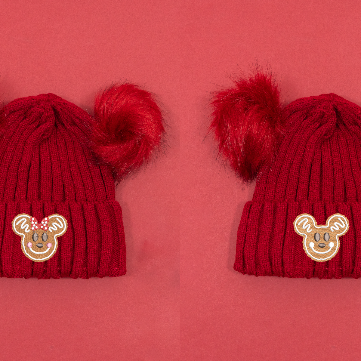 Red knitted beanies shown side by side with Minnie and Mickey gingerbread embroidery and fluffy red pom poms.