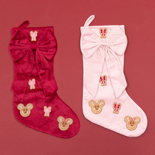 Red and pink Christmas stockings with oversized bows, Mickey and Minnie gingerbread embroidery and contrasting embroidered bows.