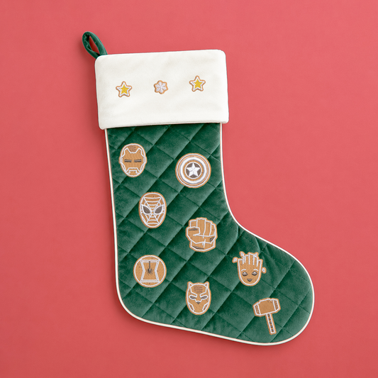 Green quilted Christmas stocking with a cream cuff, embroidered stars, snowflake and gingerbread-style Marvel superhero designs.