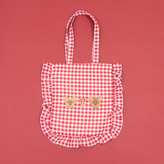 Red and white gingham tote bag with ruffled trim and Mickey and Minnie gingerbread embroidery.