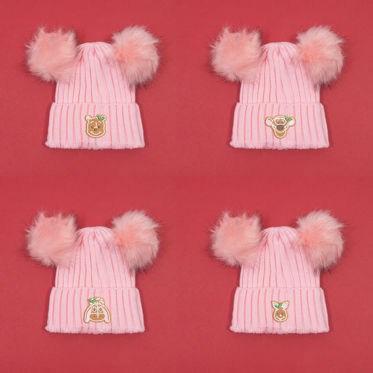 Four pink knitted beanies with twin fluffy pom poms, showing Winnie the Pooh, Tigger, Eeyore and Piglet gingerbread embroidery.