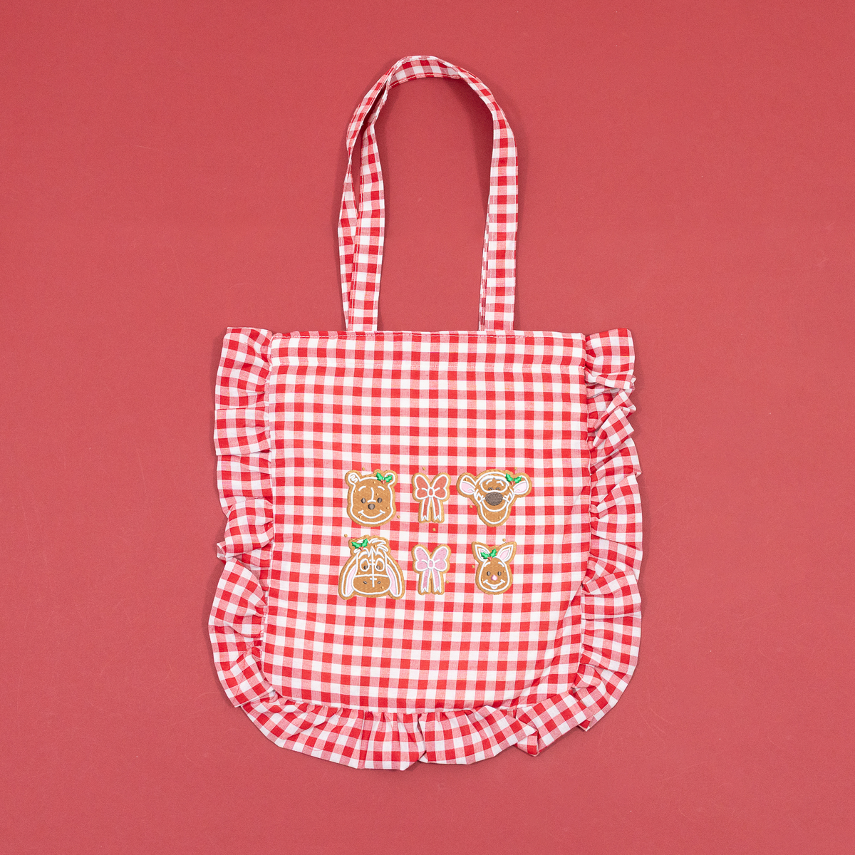 Red and white gingham tote bag with ruffled trim and Winnie the Pooh, Tigger, Eeyore and Piglet gingerbread embroidery.